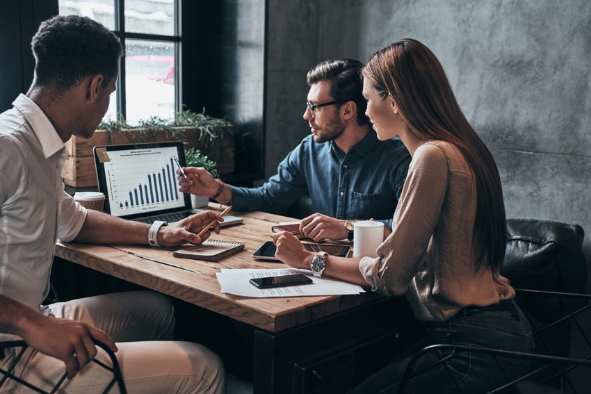 Profissionais de negócios. Grupo de jovens empresários confiantes que analisam dados usando o computador enquanto passam tempo no escritório