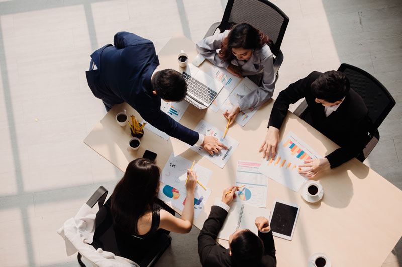 Vista superior no escritório enquanto as pessoas têm uma reunião.