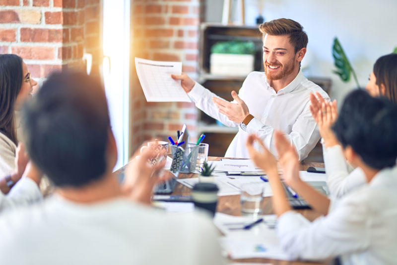 Grupo de trabalhadores de negócios sorrindo feliz e confiante. Trabalhando junto com sorriso no rosto aplaudindo um deles no escritório.