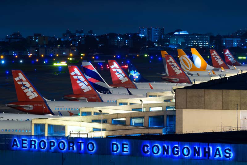 Aeroporto de Congonhas em uma noite movimentada. Caudas de aeronaves aéreas brasileiras alinhadas.